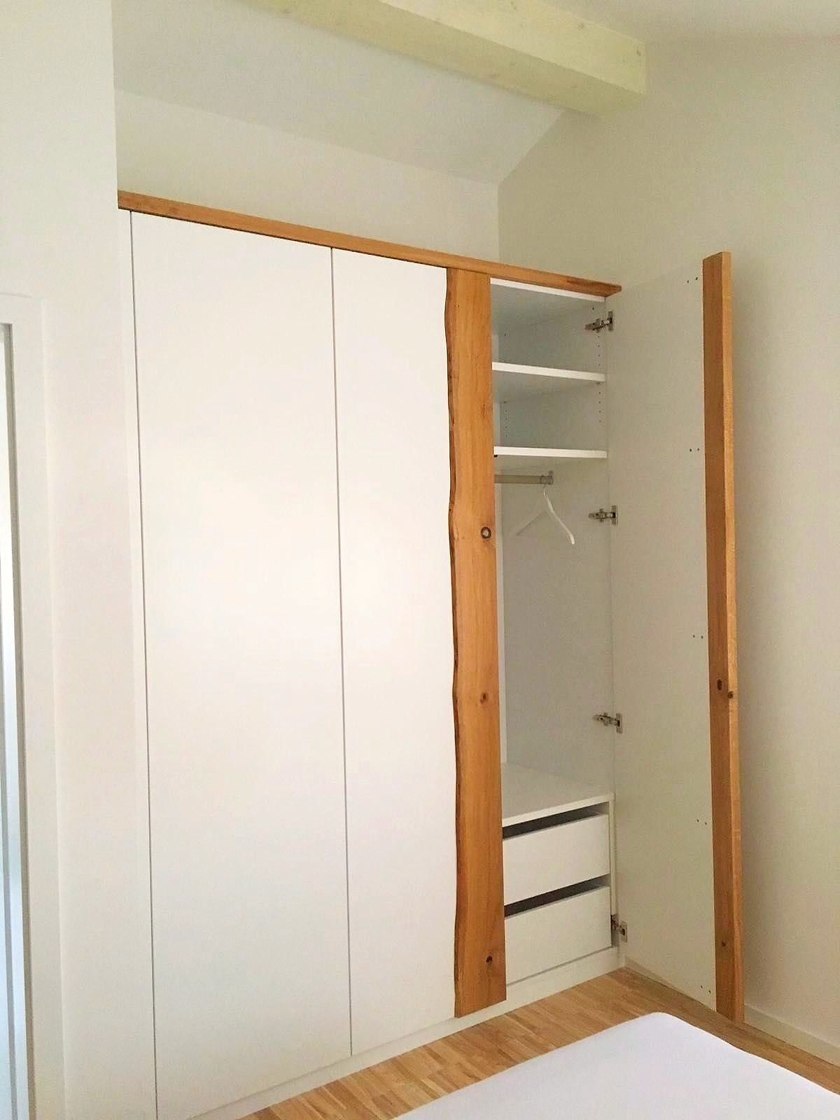 Geöffneter Einbauschrank mit Einlegeböden, Kleiderstange und Innenschubladen.