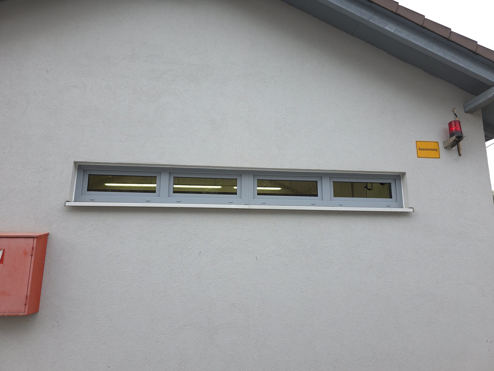 Außenansicht des fertigen Fensterbands in Silbergrau mit neuer Fensterbank – ruhig eingefügt in die Fassade.