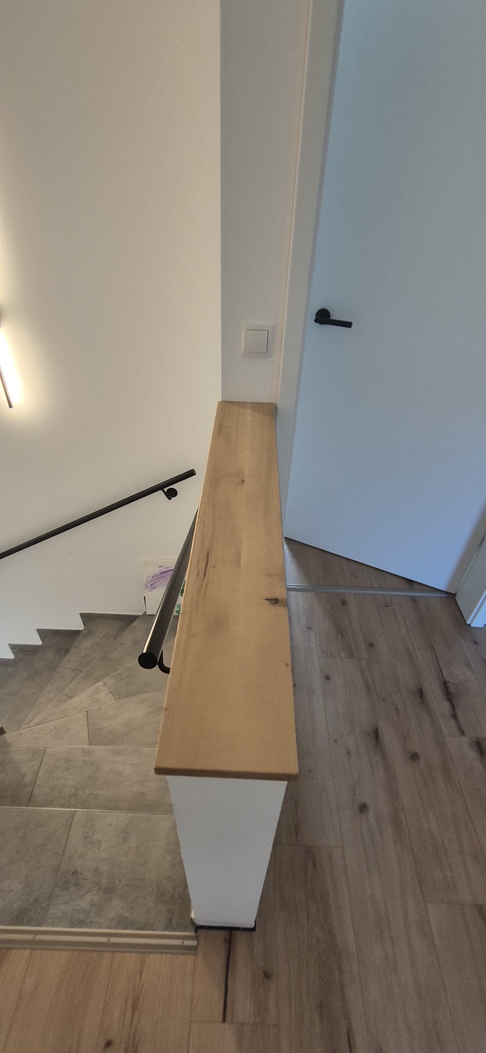 Die massive Eichen-Abdeckung sitzt fugenfrei auf der Brüstungsmauer am Treppenabgang.
